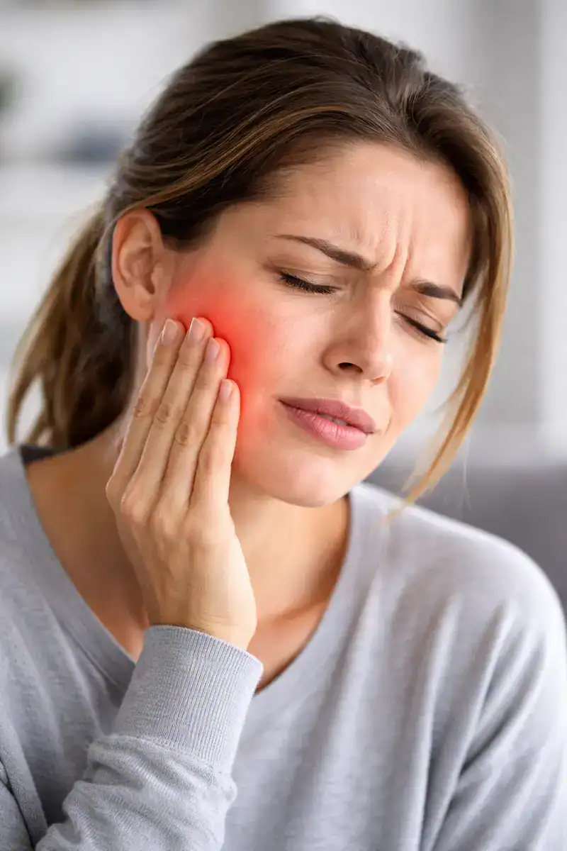 Woman experiencing jaw pain from TMJ disorder
