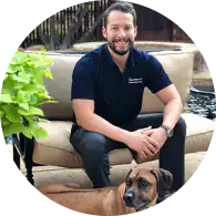 Friendly TMJ & sleep therapy expert with patient and dog outdoors.